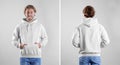 Man in blank hoodie sweater on light background, front and back views. Royalty Free Stock Photo