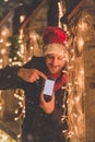 Man with blank screen smart phone and Christmas lights decoration. Technology and holidays concept. Royalty Free Stock Photo