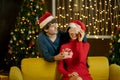 Man blindfold his lover and hold the present to make surprise to her during Christmas festival and they celebrate at home with Royalty Free Stock Photo