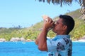 Man blowing conch shell in Bora Bora, French Polynesia