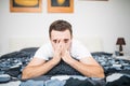 Man blowing his nose while lying sick in bed at home Royalty Free Stock Photo