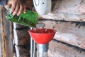 A man blows nuts from small debris using DIY device to extract cedar nuts from Siberian pine cones.