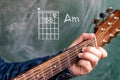 Man playing guitar chords displayed on a blackboard, Chord A minor Royalty Free Stock Photo