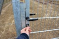 Man in a blue jacket opens with a key a gate to the garden, a paddock for tigers, bears, dogs, forest fencing highway fence. galva Royalty Free Stock Photo