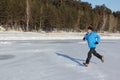 Man in a blue jacket running across the ice of a frozen river, O