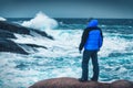 Man in blue jacket is standing on the stone on sea coast Royalty Free Stock Photo