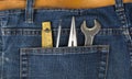 Man blue jeans back pocket with wrench meter and pencil
