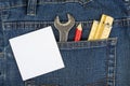Man blue jeans back pocket with wrench meter and pencil