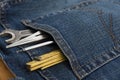 Man blue jeans back pocket with wrench meter and pencil