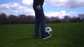 Man In Blue Jeans And Moccasins Juggling Black and White Classic Soccer Ball. People Go In For Sports. Young Boy Playing Royalty Free Stock Photo