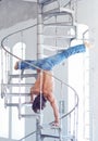 A man in blue jeans upside down on iron ladder. Royalty Free Stock Photo