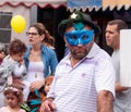 Man in blue mask stands and looks at ÃÂarnival parade Royalty Free Stock Photo