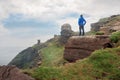 Man in blue outdoor jacket standing on a edge of a cliff enjoying majestic view. Cliffs of Moher, county Clare, Ireland. Cloudy Royalty Free Stock Photo