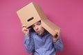 Man in blue shirt with a brown paper box on his head, hiding from job stress. Royalty Free Stock Photo