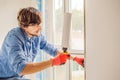 Man in a blue shirt does window installation Royalty Free Stock Photo
