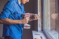 Man in a blue shirt does window installation Royalty Free Stock Photo