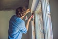 Man in a blue shirt does window installation Royalty Free Stock Photo