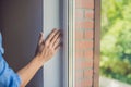 Man in a blue shirt does window installation Royalty Free Stock Photo