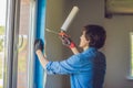 Man in a blue shirt does window installation Royalty Free Stock Photo