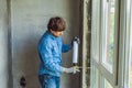 Man in a blue shirt does window installation. Using a mounting foam Royalty Free Stock Photo