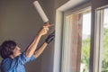 Man in a blue shirt does window installation Royalty Free Stock Photo