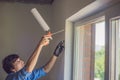 Man in a blue shirt does window installation Royalty Free Stock Photo