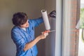 Man in a blue shirt does window installation Royalty Free Stock Photo