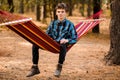 Man in blue shirt relax in hammock in forest