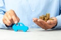 Man in blue shirt is holding car and stack of coins. Concept car purchase, taxes or insurance Royalty Free Stock Photo