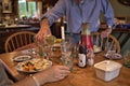 Man in blue shirt pouring white wine to glass during dinner Royalty Free Stock Photo