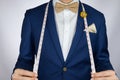 Man in blue suit bowtie, brooch, pocket square blue suit carry m Royalty Free Stock Photo