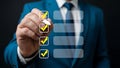 Man in blue suit checking off items on a digital to do list checklist task Royalty Free Stock Photo