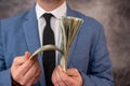 Man in blue suit count stack of dollar bills