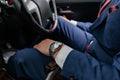 A man in a blue suit and red tie with a watch on his arm is driving a car. Royalty Free Stock Photo