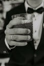 A man in a blue suit and white shirt holds a tall glass of rose wine at an event. natural light Royalty Free Stock Photo