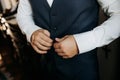 A man in a blue suit zips up his jacket, close-up. Businessman changing clothes.Tonal correction. FASHION, STYLE