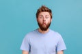 Man in blue T-shirt standing with fish lips and looking at camera, childish behavior, having fun. Royalty Free Stock Photo