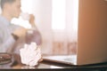 Man in blur, laptop, coffee cup and crumpled wads on table. new idea