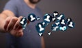 Man on blurred background touching a group of illustrative 3D rendered user icons floating in air