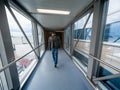 Man boarding in airport gate or jet bridge or jetway or airbridge to a plane Royalty Free Stock Photo