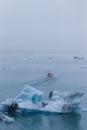 Man on a boat between bizarre ice floes of Iceberg lagoon jokulsarlon on the south of Iceland Royalty Free Stock Photo
