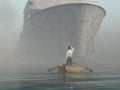 Man in boat looking on approaching vessel