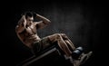 Man bodybuilder perform exercise on prelum abdominale on bench Royalty Free Stock Photo