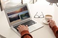 Man booking tickets online on laptop at white table, closeup. Travel agency concept