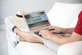 Man booking tickets online on sofa indoors, closeup. Travel agency concept