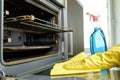Man with bottle of spray and rag cleaning oven Royalty Free Stock Photo