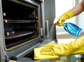 Man with bottle of spray and rag cleaning oven Royalty Free Stock Photo