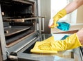 Man with bottle of spray and rag cleaning oven Royalty Free Stock Photo