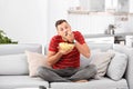 Man with bowl of potato chips sitting on sofa Royalty Free Stock Photo