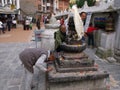 A man bows at a sacred sculpture at the Boudhanath stupa in Kathmandu, Nepal